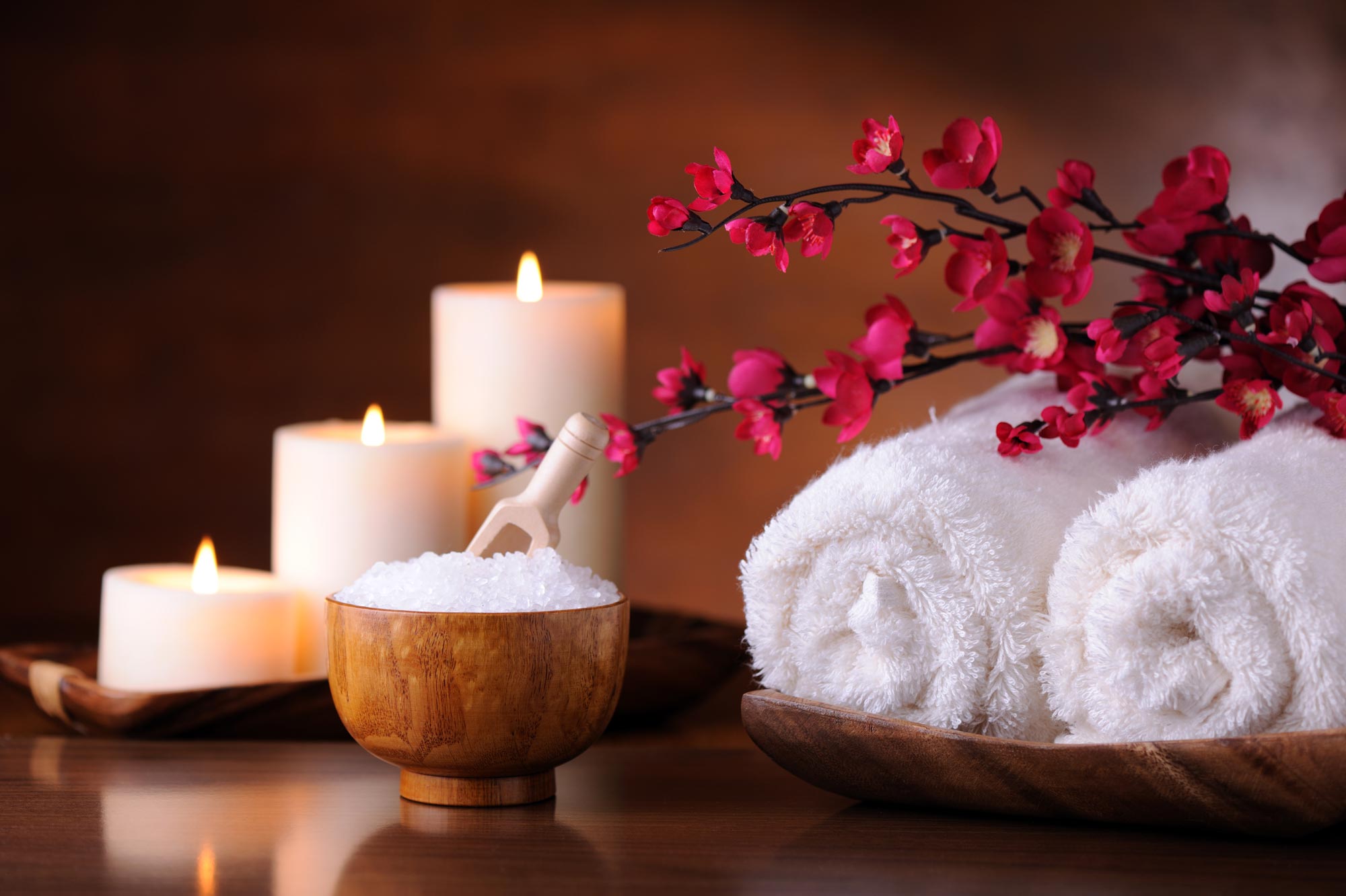Ljus, badsalt och handdukar på ett spa